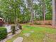The backyard features a wooded area, a stepping stone pathway, and partial privacy fence at 7501 Montibillo Pkwy, Durham, NC 27713
