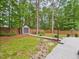 Well-maintained backyard featuring a shed, mature trees, and a charming wooden walkway for a serene outdoor space at 7501 Montibillo Pkwy, Durham, NC 27713