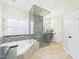Bathroom with soaking tub, glass shower, granite countertops, and mosaic tile accents at 7501 Montibillo Pkwy, Durham, NC 27713