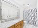 Bathroom with granite vanity, updated mirror and lighting, and shower-tub with modern curtain at 7501 Montibillo Pkwy, Durham, NC 27713