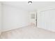 Bright bedroom with neutral carpet, fresh paint, closet, and doorway to additional rooms at 7501 Montibillo Pkwy, Durham, NC 27713