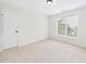 Bright vacant bedroom featuring neutral carpet, fresh paint, and a window for natural light at 7501 Montibillo Pkwy, Durham, NC 27713