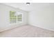 Bright bedroom featuring neutral carpet, a large window, and fresh paint at 7501 Montibillo Pkwy, Durham, NC 27713