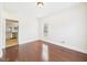 Bright bedroom with hardwood floors, window, and access to the kitchen at 7501 Montibillo Pkwy, Durham, NC 27713