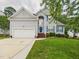Charming two-story home featuring a well-manicured lawn, two-car garage, and a welcoming blue front door at 7501 Montibillo Pkwy, Durham, NC 27713