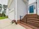 Close-up of the brick stairs with black railings leading to a blue front door and two-car garage at 7501 Montibillo Pkwy, Durham, NC 27713