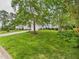 Beautifully landscaped front yard with mature trees, green grass, and charming home exterior at 7501 Montibillo Pkwy, Durham, NC 27713