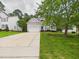 Lovely home with a long driveway, two-car garage, blue door, and lush green lawn at 7501 Montibillo Pkwy, Durham, NC 27713