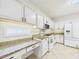 Kitchen featuring granite countertops, white cabinets, and appliances at 7501 Montibillo Pkwy, Durham, NC 27713