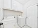Laundry room features white cabinets, white tile floors and updated machines at 7501 Montibillo Pkwy, Durham, NC 27713
