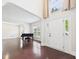 Bright living room with rich hardwood floors and a piano by the front door at 7501 Montibillo Pkwy, Durham, NC 27713