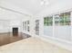 Bright sunroom with large windows, tile flooring, and neutral walls leading to a fireplace at 7501 Montibillo Pkwy, Durham, NC 27713