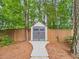 Backyard shed offering extra storage, nestled among mature trees and landscaping at 7501 Montibillo Pkwy, Durham, NC 27713