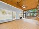 Wood-paneled sunroom featuring large windows, skylights, and a cozy stove, perfect for relaxation at 7501 Montibillo Pkwy, Durham, NC 27713