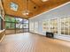 Inviting sunroom with wood-paneled ceiling, ample windows, and a cozy stove offering a tranquil retreat at 7501 Montibillo Pkwy, Durham, NC 27713
