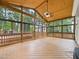 Large sunroom with wood detailing, screened windows, and a ceiling fan creating a serene outdoor space at 7501 Montibillo Pkwy, Durham, NC 27713