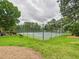 Two community tennis courts surrounded by a chain link fence and mature trees at 7501 Montibillo Pkwy, Durham, NC 27713