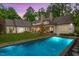 Stunning backyard featuring a sparkling pool, stone patio, and lush landscaping perfect for outdoor entertaining at 800 Lakestone Dr, Raleigh, NC 27609