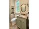 Charming bathroom featuring a vintage style vanity with stone countertop and built-in shelving near a window at 800 Lakestone Dr, Raleigh, NC 27609