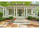Charming front porch with white columns, rocking chairs, and lush greenery, creating a welcoming entrance at 800 Lakestone Dr, Raleigh, NC 27609