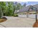 Spacious three-car garage with a basketball hoop and ample driveway space, nestled among mature trees at 800 Lakestone Dr, Raleigh, NC 27609