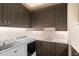 Well-lit laundry room features front load washer and dryer, built-in cabinets, and white countertop with sink at 800 Lakestone Dr, Raleigh, NC 27609