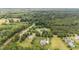 An aerial view shows neighborhood homes amidst a canopy of trees and open space at 100 Virginia Lee Ln, Efland, NC 27243