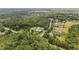 Aerial shot displays homes, some with pools, surrounded by a dense forest at 100 Virginia Lee Ln, Efland, NC 27243