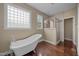 Elegant bathroom featuring a clawfoot tub, glass block window, and tiled walk-in shower at 100 Virginia Lee Ln, Efland, NC 27243