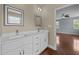 Bright bathroom featuring a double vanity with white cabinets and a bedroom view at 100 Virginia Lee Ln, Efland, NC 27243