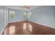 Light blue primary bedroom with wood floors, ceiling fan and natural light from large windows at 100 Virginia Lee Ln, Efland, NC 27243