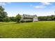 Charming home boasts a welcoming porch, complemented by lush green lawn and mature trees at 100 Virginia Lee Ln, Efland, NC 27243