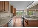 Bright kitchen with granite countertops, stainless steel appliances, and wood floors leading to dining area at 100 Virginia Lee Ln, Efland, NC 27243
