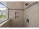 Updated shower with tiled walls, built-in shelves and a window to provide natural light at 100 Virginia Lee Ln, Efland, NC 27243