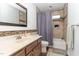 Bathroom featuring a shower-tub combo, brown mosaic tile backsplash, vanity, and modern mirror at 1001 Kingsway Dr, Apex, NC 27502