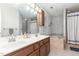 Well-lit bathroom with a double sink vanity, bathtub, and tile surround at 1001 Kingsway Dr, Apex, NC 27502