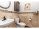Elegant half bath with decorative tile accents, pedestal sink, and a wall-mounted cabinet at 1001 Kingsway Dr, Apex, NC 27502