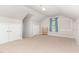 Spacious bedroom featuring neutral carpet, light walls, window with blue curtains, and ample closet space at 1001 Kingsway Dr, Apex, NC 27502