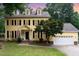 Charming yellow two-story home with black shutters and manicured lawn and white garage door at 1001 Kingsway Dr, Apex, NC 27502