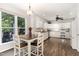 Bright kitchen featuring white cabinets, white appliances, hardwood floors, and lots of natural light at 1001 Kingsway Dr, Apex, NC 27502