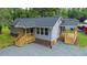 Newly renovated single-story home with blue door and two inviting covered decks, landscaped with gravel at 1006 S Second Ave Ave, Siler City, NC 27344