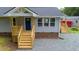 Inviting front porch with craftsman railings leads to a blue front door with adjacent windows at 1006 S Second Ave Ave, Siler City, NC 27344