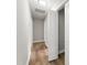 A clean hallway with neutral colored walls, hardwood floors, and storage closets at 1006 S Second Ave Ave, Siler City, NC 27344