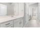 White bathroom vanity features a large mirror, granite countertops and white cabinets with dark hardware at 1007 Epiphany Rd, Morrisville, NC 27560