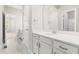White bathroom vanity features a large mirror, granite countertops and white cabinets with dark hardware at 1007 Epiphany Rd, Morrisville, NC 27560