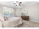 Bright bedroom featuring a ceiling fan, a large window and a wooden dresser at 1007 Epiphany Rd, Morrisville, NC 27560