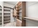 Walk-in closet features custom wood shelving, drawers and ample hanging space for clothing and accessories at 1007 Epiphany Rd, Morrisville, NC 27560