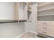 Organized walk-in closet featuring wooden shelving, drawers, and black hanging rods for optimal storage solutions at 1007 Epiphany Rd, Morrisville, NC 27560
