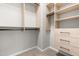 Walk-in closet features custom wood shelving, drawers and ample hanging space for clothing and accessories at 1007 Epiphany Rd, Morrisville, NC 27560