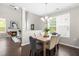Open-concept dining area with modern chandelier, hardwood floors, and natural light at 1007 Epiphany Rd, Morrisville, NC 27560